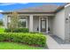 Charming front porch with decorative glass door, manicured landscaping, and modern outdoor lighting at 6670 Paden Wheel St, Zephyrhills, FL 33541