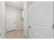 Hallway with tiled floors, multiple doors, and storage closet with wire shelving at 6670 Paden Wheel St, Zephyrhills, FL 33541