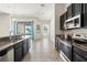 Open-concept kitchen boasts granite countertops, stainless steel appliances, and seamless transition to the living area and pool at 6670 Paden Wheel St, Zephyrhills, FL 33541