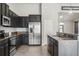 Modern kitchen with granite counters, stainless steel appliances, tile backsplash, and dark wood cabinetry at 6670 Paden Wheel St, Zephyrhills, FL 33541