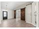 Open-concept living room boasts stylish barn doors, ceramic tile, and a decorative front door at 6670 Paden Wheel St, Zephyrhills, FL 33541