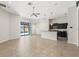 Open-concept living room featuring a kitchen with dark cabinets and a view of the pool at 6670 Paden Wheel St, Zephyrhills, FL 33541