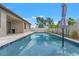 Backyard swimming pool with stone patio, umbrellas and blue water at 6670 Paden Wheel St, Zephyrhills, FL 33541