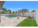 A backyard pool with turf, pavers, and tropical landscaping at 6670 Paden Wheel St, Zephyrhills, FL 33541
