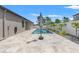 Outdoor pool with travertine pavers, turf and tropical landscaping at 6670 Paden Wheel St, Zephyrhills, FL 33541