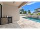 Outdoor kitchen area on the pool deck with cooler and view of backyard and pool at 6670 Paden Wheel St, Zephyrhills, FL 33541