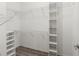 Bright walk-in closet featuring white wire shelving and wooden-look flooring at 6670 Paden Wheel St, Zephyrhills, FL 33541