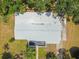 Aerial view of a home with a bright roof, set on a well-maintained lot with trees and landscaping at 695 Sunset Dr, Tarpon Springs, FL 34689