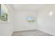 This bright bedroom features two windows, white walls and gray wood-look flooring at 695 Sunset Dr, Tarpon Springs, FL 34689
