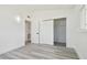 Bright bedroom features a closet, and gray wood-look flooring, with white walls at 695 Sunset Dr, Tarpon Springs, FL 34689