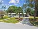 Charming single-story home with well-manicured front yard and palm trees at 695 Sunset Dr, Tarpon Springs, FL 34689