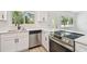 Close-up of the kitchen featuring stainless steel appliances, white countertops, and natural light at 695 Sunset Dr, Tarpon Springs, FL 34689