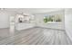Bright living room with sleek gray flooring and a large window, flowing into the kitchen at 695 Sunset Dr, Tarpon Springs, FL 34689