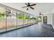 Spacious, screened lanai with ceiling fans and a dark decorative concrete floor at 695 Sunset Dr, Tarpon Springs, FL 34689