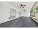 Screened in porch with ceiling fans and sliding glass doors with dark concrete flooring at 695 Sunset Dr, Tarpon Springs, FL 34689