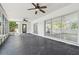 Large sunroom featuring ceiling fans, concrete flooring, and screened windows and doors at 695 Sunset Dr, Tarpon Springs, FL 34689