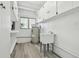 Utility room with storage cabinets, laundry sink, and updated flooring at 695 Sunset Dr, Tarpon Springs, FL 34689