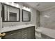 Bathroom boasts dual sinks, a marble countertop, and updated gray shower tile at 7013 Early Gold Ln, Riverview, FL 33578
