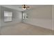 Neutral bedroom features wainscoting, dual windows, and a ceiling fan at 7013 Early Gold Ln, Riverview, FL 33578