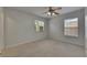 Carpeted bedroom with two windows and a ceiling fan at 7013 Early Gold Ln, Riverview, FL 33578