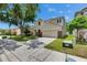 Two-story home with a two-car garage, stone accents, manicured lawn, and mature trees at 7013 Early Gold Ln, Riverview, FL 33578