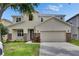 Two-story home with a two-car garage, stone accents, and a well-maintained lawn at 7013 Early Gold Ln, Riverview, FL 33578