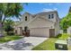 Two-story home with a well-maintained lawn, stone accents, and an attached garage at 7013 Early Gold Ln, Riverview, FL 33578