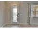 The foyer with a glass-accented door and light wood flooring at 7013 Early Gold Ln, Riverview, FL 33578