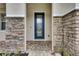 Front door with a glass insert and stone facade accents at 7013 Early Gold Ln, Riverview, FL 33578