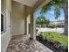 View of the front porch with brick pavers and landscaping, showcasing the neighborhood street at 7013 Early Gold Ln, Riverview, FL 33578