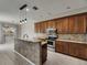 Lovely kitchen featuring stainless steel appliances, wood cabinets, tile backsplash, and a center island with bar seating at 7013 Early Gold Ln, Riverview, FL 33578