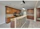 Modern kitchen features an island with seating, stainless steel appliances, and wood cabinets for a sleek and stylish look at 7013 Early Gold Ln, Riverview, FL 33578