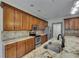 Well-lit kitchen featuring wooden cabinets, stainless steel appliances, and granite countertops at 7013 Early Gold Ln, Riverview, FL 33578