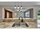A kitchen sink with black faucet sits in front of a breakfast bar, with a view of the living room at 7013 Early Gold Ln, Riverview, FL 33578