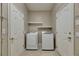 A laundry room featuring a white washer, a dryer, white walls and two white doors at 7013 Early Gold Ln, Riverview, FL 33578