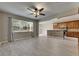 Open-concept living space with views of the kitchen features grey wood-look flooring and natural light from the large window at 7013 Early Gold Ln, Riverview, FL 33578