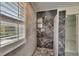 Close up of shower stall featuring marble-look tile and updated shower head at 7013 Early Gold Ln, Riverview, FL 33578