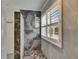 Stylishly appointed shower featuring black marble accent tiles and a bright window with plantation shutters at 7013 Early Gold Ln, Riverview, FL 33578