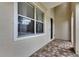 View of the side porch area with brick pavers, a window, and a door at 7013 Early Gold Ln, Riverview, FL 33578