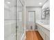 Bright bathroom with double sinks, a walk-in shower, and a convenient pet door to the backyard at 71 Flamingo Cir, Safety Harbor, FL 34695