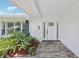 Inviting front entrance with decorative landscaping, a white door, and a brick paved walkway at 71 Flamingo Cir, Safety Harbor, FL 34695