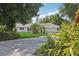 Attractive single-story home with a well-manicured lawn and long driveway surrounded by mature shade trees at 71 Flamingo Cir, Safety Harbor, FL 34695