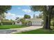 Well maintained single-story home with a lush green lawn and mature tropical landscaping at 71 Flamingo Cir, Safety Harbor, FL 34695