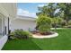 Cozy side porch with decorative landscaping and chairs for outdoor relaxation and enjoyment at 71 Flamingo Cir, Safety Harbor, FL 34695