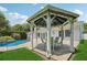 Enjoy outdoor dining under the gazebo, nestled next to a sparkling pool and lush landscaping at 71 Flamingo Cir, Safety Harbor, FL 34695