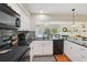 Contemporary kitchen featuring updated appliances, white cabinets, and a view into the sunny living space at 71 Flamingo Cir, Safety Harbor, FL 34695