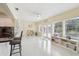 Sunny living space with white floors, large windows, and an open connection to the kitchen at 71 Flamingo Cir, Safety Harbor, FL 34695