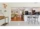 Open-concept living room and kitchen with white cabinets, black appliances, and hardwood floors at 71 Flamingo Cir, Safety Harbor, FL 34695