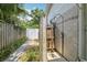Private outdoor shower with stone wall and wood enclosure near tropical garden at 71 Flamingo Cir, Safety Harbor, FL 34695
