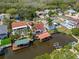 Waterfront home with a red tile roof, private dock, and lush tropical landscaping at 77 Gulfwinds Dr, Palm Harbor, FL 34683
